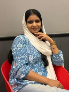 Portrait of a freelance digital marketing specialist in Qatar sitting confidently in a modern indoor setting.
