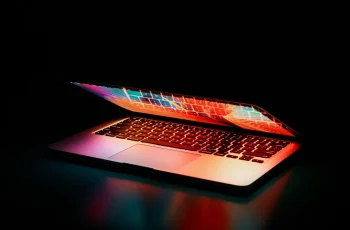 Freelance digital marketing specialist in Qatar concept with a laptop on a dark minimalist desk, representing a modern workspace setup.